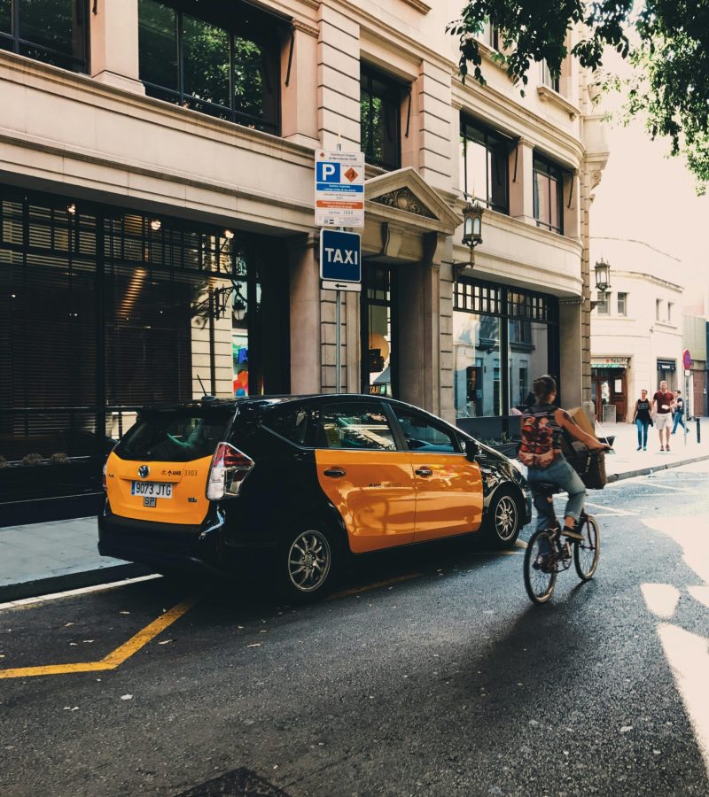 Taxi estacionado y una bici al lado en una parada